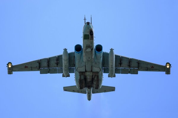 Бронированный дозвуковой штурмовик су-25 летает в голубом небе